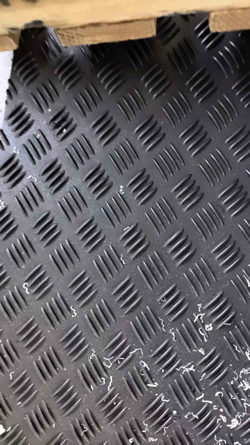 Close-up of black HDPE mat with anti-slip tread pattern