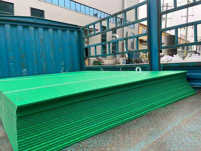 Green HDPE mats stacked in the factory yard